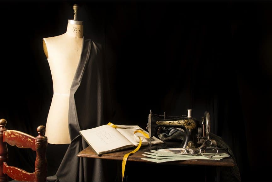 Vintage tailor's atelier with a dress form, draped cloth and an antique sewing machine