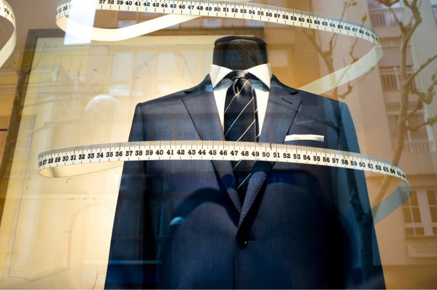 Navy pinstripe suit in a shop window wrapped in a measuring tape